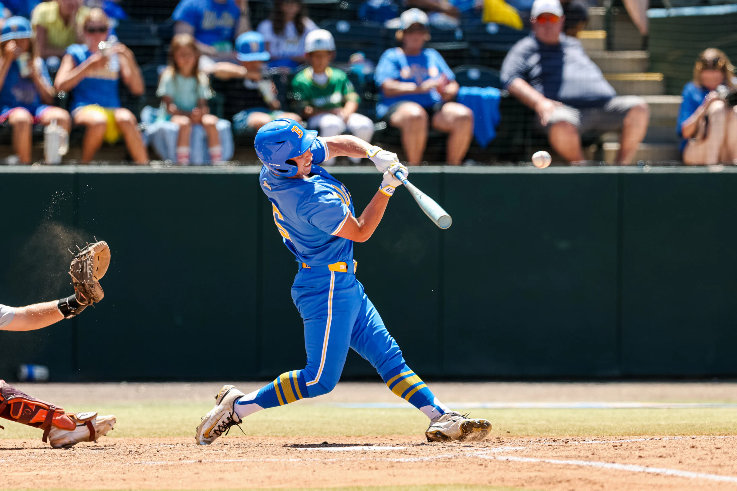 Jarrod Hocking swinging at a pitch in a blue and gold college baseball uniform